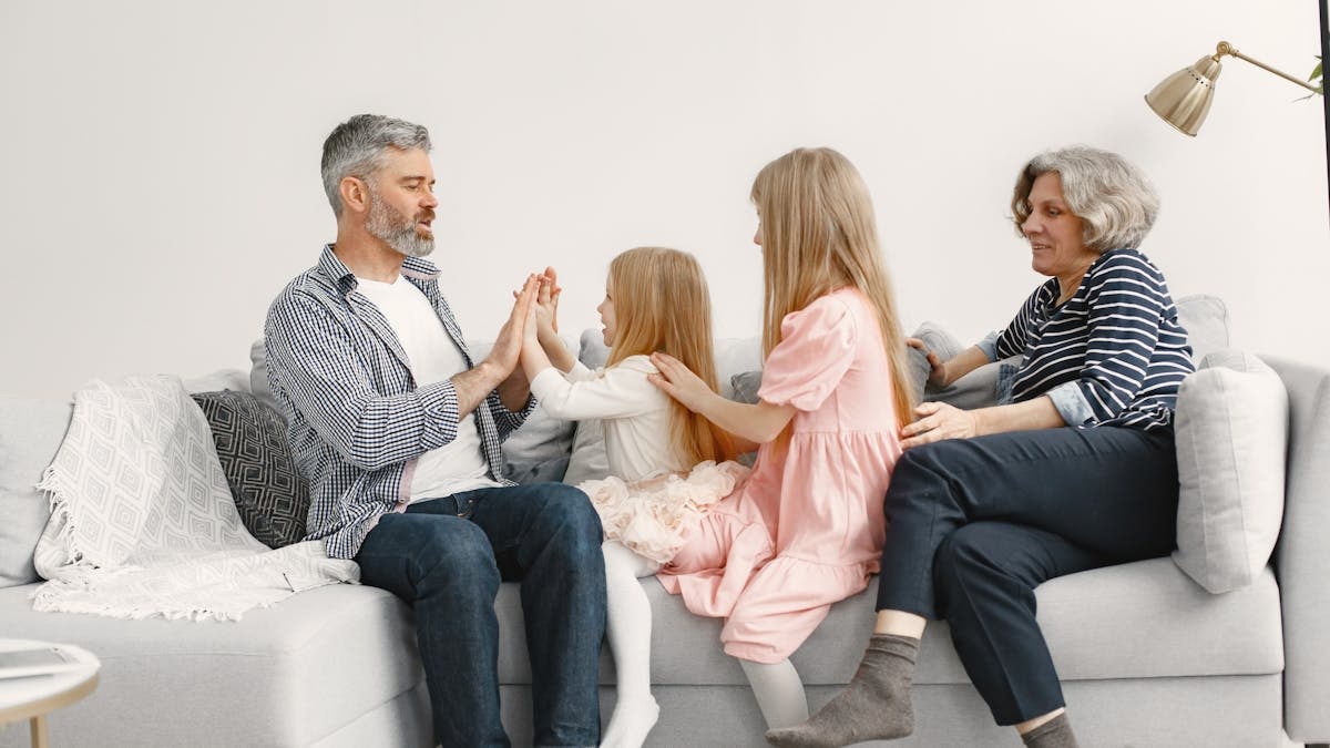 A joyful family spends quality time together, playing and bonding on a cozy sofa.